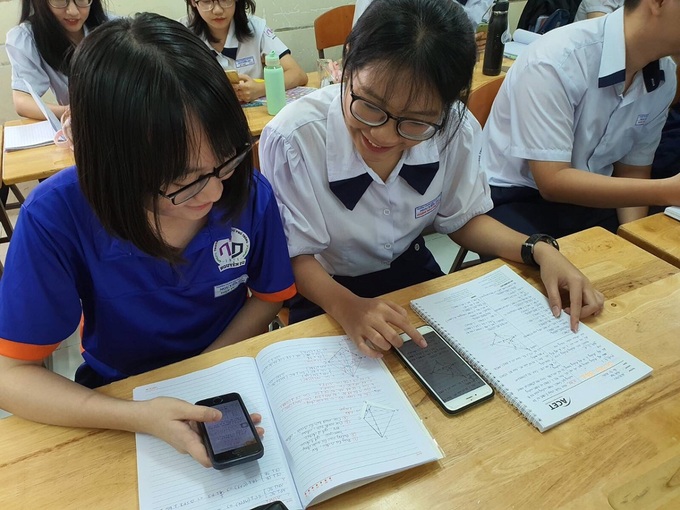 Học sinh trường THPT Nguyễn Du (quận 10, TP HCM) trong một tiết học có sử dụng điện thoại dưới sự hướng dẫn của giáo viên. Ảnh: Vnexpress
