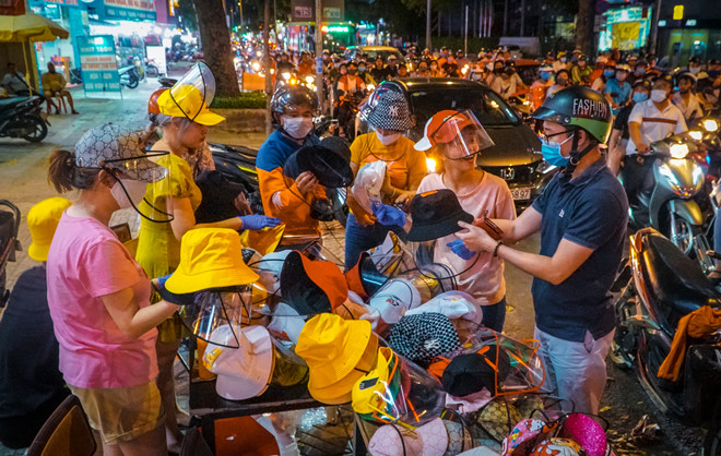 Người dân mua nón chống dịch/ nón chống giọt bắn trên vỉa hè Q.10, TP.HCM - Ảnh Thanh Niên