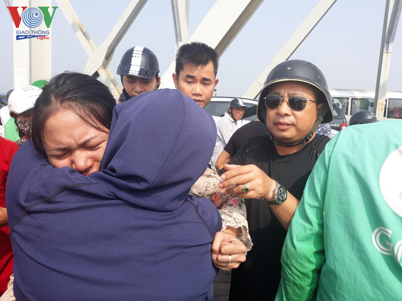 Sau một khoảng thời gian khuyên nhủ, đồng chí Tạ Quang Dũng, CSGT Đội 5, cùng người dân đưa được người phụ nữ vào trong cầu. 