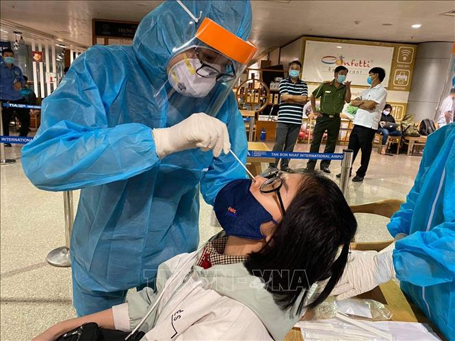 Nhân viên y tế lấy mẫu xét nghiệm cho người làm việc tại sân bay Tân Sơn Nhất ngày 6/2/2021. Ảnh minh họa: TTXVN 