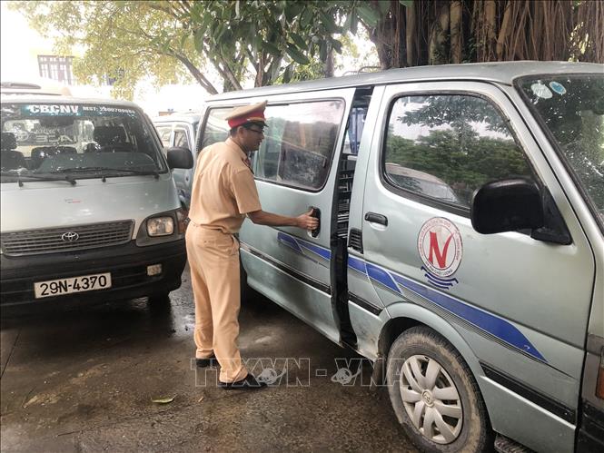 Cảnh sát giao thông kiểm tra một xe ô tô chở học sinh bị tạm giữ. 