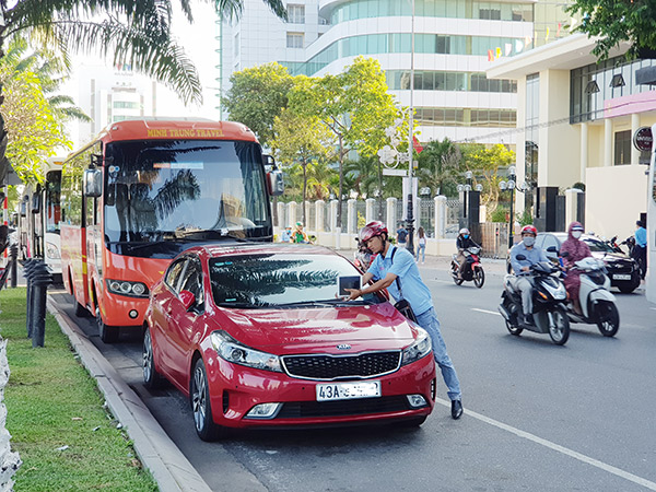 Dán thông báo thu phí đối với các xe ô tô sử dụng lòng đường để đậu đỗ trên hai tuyến đường Bạch Đằng, Trần Phú