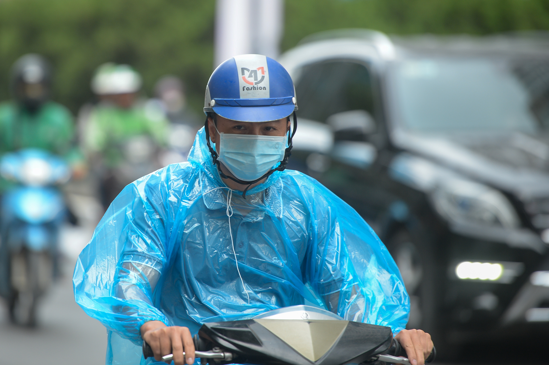 Hà Nội giảm nhiệt sâu, người dân trùm áo mưa tránh rét