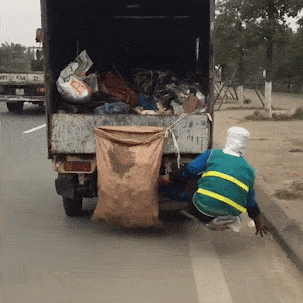 Hình ảnh một công nhân thu gom rác, ngồi phía sau xe để nhặt rác từng khiến CĐM thất kinh.