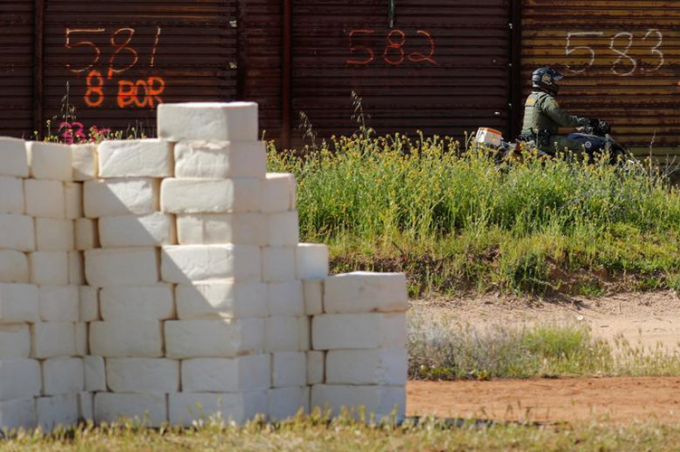 Một nhân viên tuần tra biên giới Mỹ đi qua đoạn tường biên giới xây bằng pho mát ngày 28/3.