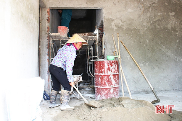 Bà Trần Thị Nhuệ trộn vữa phụ giúp chồng làm nhà.