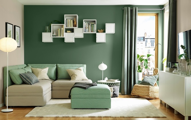 Những bức tường màu xanh lá cây trong phòng khách hiện đại kết hợp với sofa và các thiết bị nội thất màu trắng điểm nhấn.