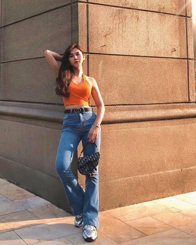 Quần jeans ống loe với phần trên bó sát, mix cùng crop top cổ yếm sẽ giúp Thu Hoài khoe được đường cong gợi cảm.