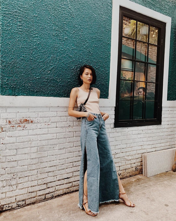 Vee Nguyễn khoe khéo đôi chân đai miên man khi chọn quần jeans ống loe xẻ vạt cao, kết hợp tank top bó sát và sandals phóng khoáng.
