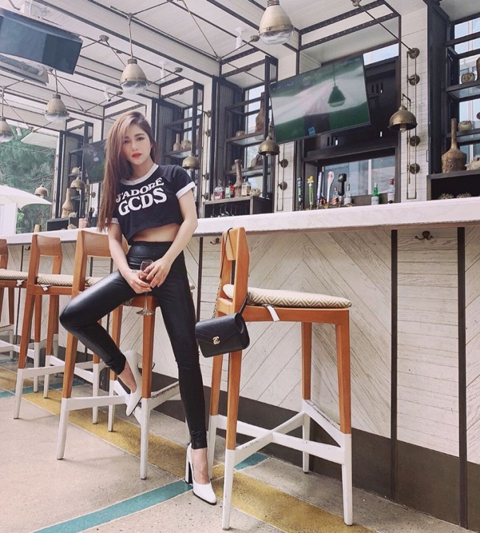 Hương Tràm gợi cảm với crop top GCDS, phối quần da bó tiệp màu đen và tạo điểm sáng bằng đôi giày trắng gót vuông cổ điển.
