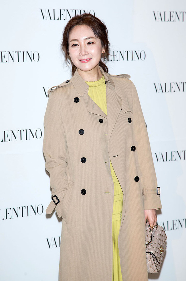 Dù nhan sắc lúc lên lúc xuống nhưng phải khẳng định một điều phong cách của Choi Ji Woo luôn ổn định. Nữ diễn viên U40 thanh lịch sang trọng với váy liền diện cùng trench coat khi xuất hiện tại sự kiện thời trang.