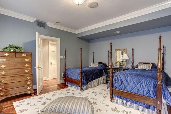 Phòng ngủ rộng rãi với hai chiếc giường, phủ drap màu xanh. Phía dưới sàn nhà được trải thảm theo phong cách quý tộc.