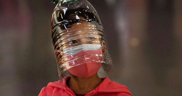 Một cô gái đội chai nhựa để bảo vệ mình trong khi chờ đợi làm thủ tục cho chuyến bay tại sân bay thủ đô Bắc Kinh.