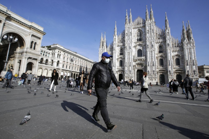 Một người đeo khẩu trang đi trước nhà thờ Duomo ở Milan, Italy, hôm 24/2. Ảnh: AP.