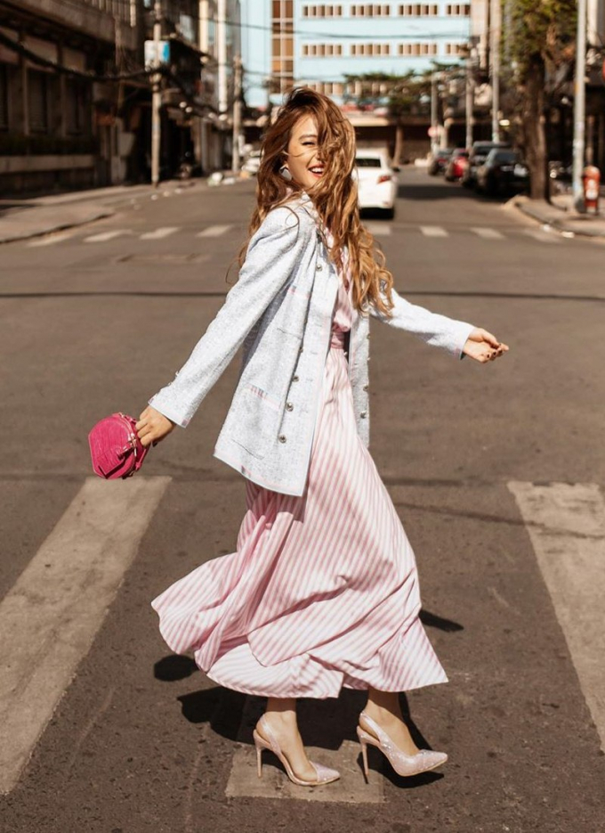 Combo váy đầm hồng phấn được Hoàng Thùy Linh kết hợp ăn ý với blazer phủ sắc pastel. Chiếc túi mini màu hồng neon chính là phụ kiện nhấn hoàn hảo cho set đồ dạo phố của chủ nhân bản hit “Duyên Âm”.