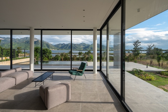 Các cửa kính cao và rộng có tác dụng mở không gian, kết hợp với vách bê tông mỏng giúp ngôi nhà kết nối với cảnh quan xung quanh.