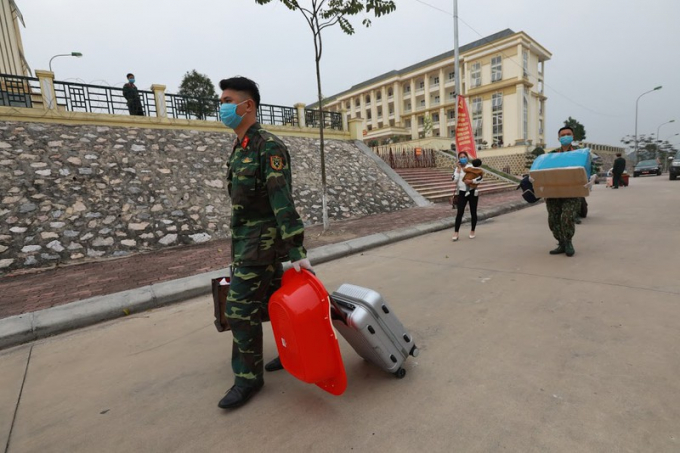 Các chiến sĩ giúp công dân chuyển hành lý ra xe về địa phương sau khi hoàn thành 14 ngày cách ly (Ảnh: Quang Vinh)