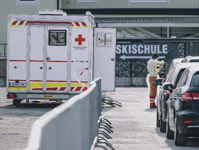 Một nhân viên Hội Chữ thập đỏ lấy mẫu tại trạm xét nghiệm COVID-19 ở Schuettdorf, Áo vào ngày 26-3. Ảnh: APA