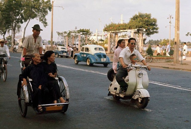 Xe xích lô chạy trên đường phố Sài Gòn cùng với các phương tiện khác như ôtô, xe máy.