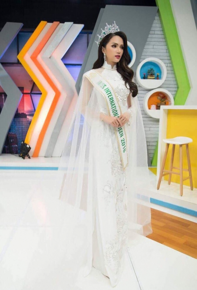 Cũng mang tà áo dài trắng nhưng không phải nguyên bản của nữ sinh trung học, Hương Giang ăn điểm ngọt hơ khi xuất hiện như bà hoàng trên sóng truyền hình Thái Lan sau khi đăng quang Hoa hậu chuyển giới Quốc tế 2018.