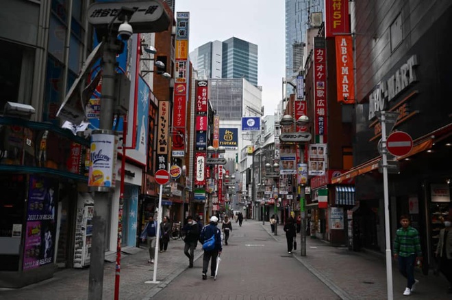 Người đi bộ trên đường phố vắng lặng hôm 5/4 ở khu Shibuya vốn là nơi sầm uất ở Tokyo. Ảnh: AFP.