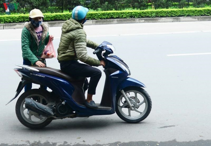 Nhiều đôi đang đi xe tay ga trên đường thấy điểm phát miễn phí cũng dừng xe vào lấy 1 túi quà.