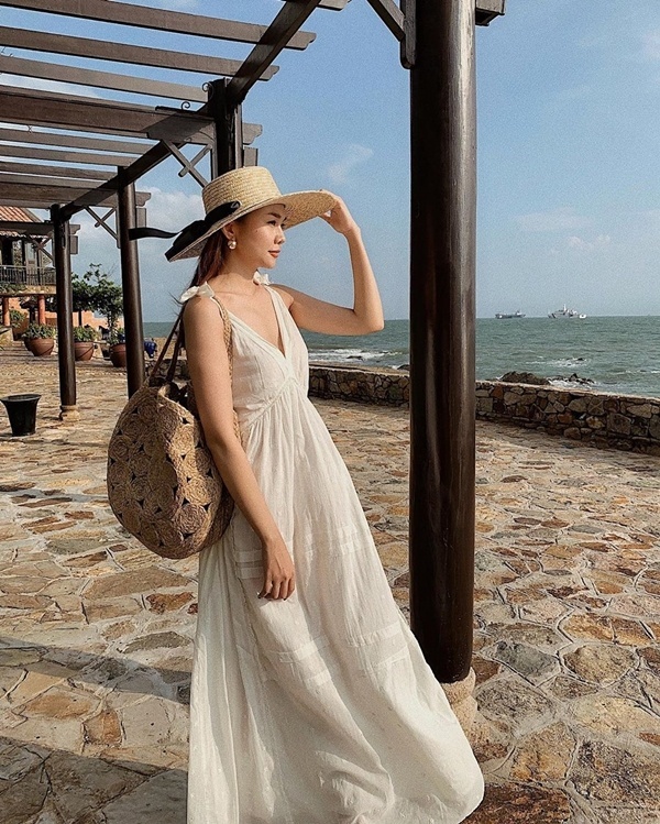 Những mẫu đầm maxi trắng xẻ ngực gợi cảm như Thanh Hằng thật sự là món đồ đáng sắm cho tủ đồ đi biển cho chị em trong mùa hè này. Đừng quên hoàn thiện set đồ bằng phụ kiện mũ cói và túi cói.