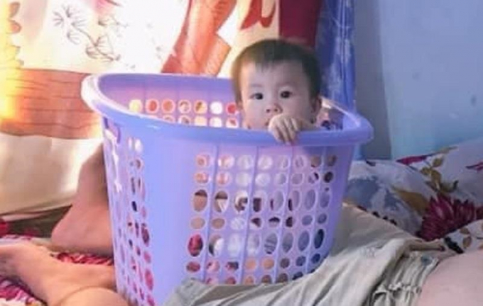 Bố cho con vào sọt để nằm chơi điện thoại cho...an toàn. (Ảnh: Khánh Uyên)
