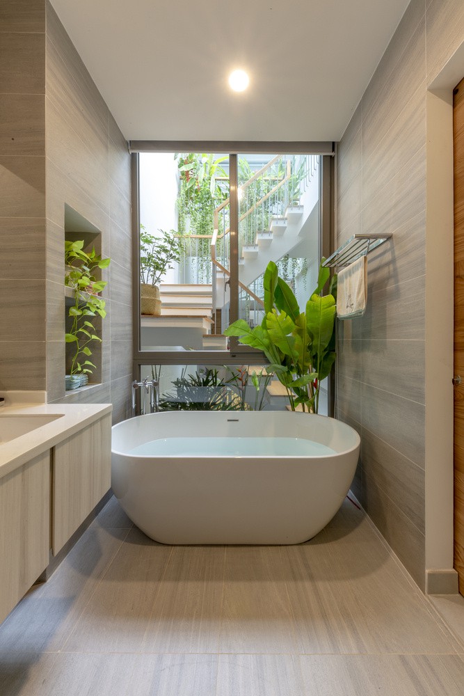 Phòng tắm thiết kế mở nhìn ra khu vực cầu thang, giếng trời với cây xanh ngập tràn.