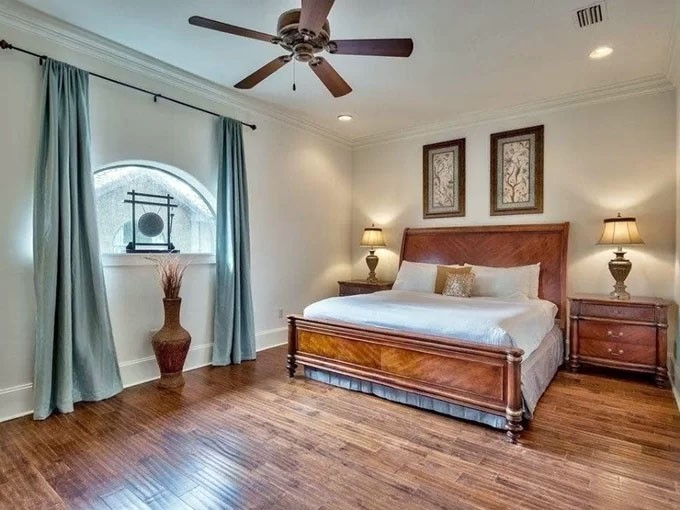 Phòng ngủ được trang hoàng phong cách quý tộc với sàn gỗ họa tiết lạ mắt, giường kiểu hoàng gia và cửa sổ vòm.