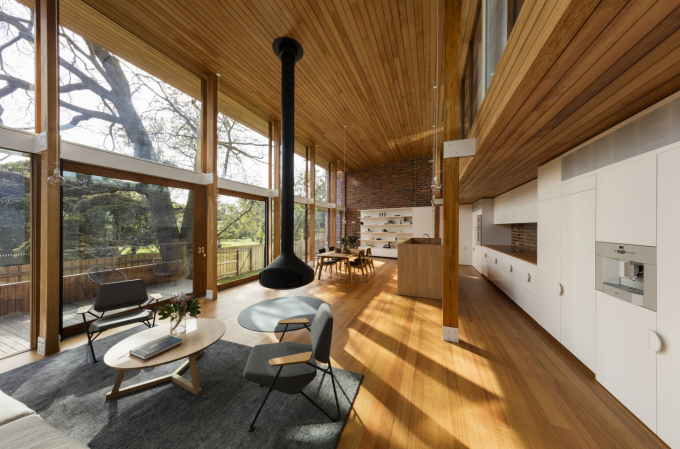 Không gian sinh hoạt chung thoáng đãng với trần nhà cao và nan gỗ sang trọng.