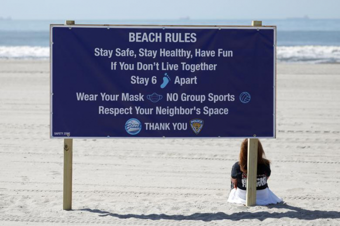 Người phụ nữ ngồi trên bãi biển Long Beach, Long Island, hôm 22/5, ngày đầu tiên các bãi biển ở New York được mở cửa trở lại kể từ khi lệnh phong tỏa được ban hành vì dịch bệnh COVID-19 bùng phát.