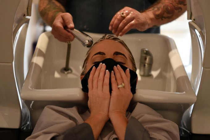 Người phụ nữ dùng khăn thay khẩu trang khi gội đầu tại một tiệm làm tóc ở Houston, bang Texas, ngày 8/5.
