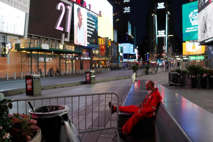 Một nhân viên dọn vệ sinh ngồi nghỉ tại khu vực Quảng trường Thời đại vắng tanh sau 20 giờ tối 6/6.