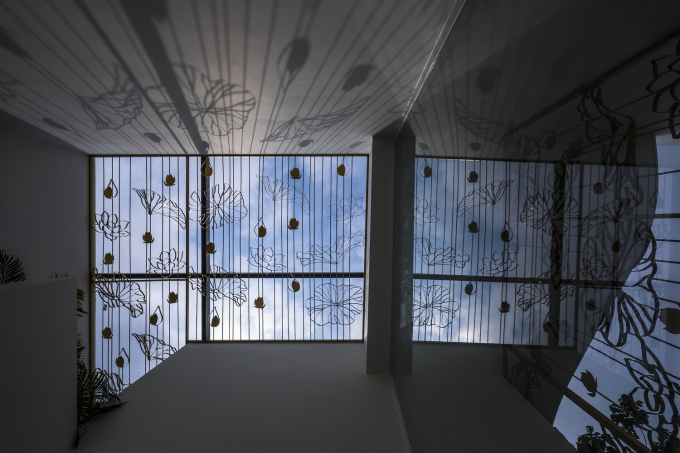 Đặc biệt, mái che giếng trời sử dụng khung sắt họa tiết hoa sen đồng bộ với thiết kế ngoại thất, đổ bóng râm đẹp mắt xuống sàn nhà khi nắng chiếu qua. Nguồn ảnh: Hiroyuki Oki.