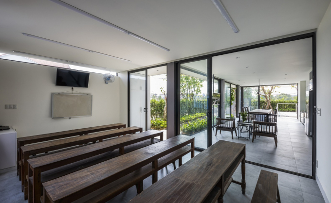 Phòng dạy tiếng Nhật tại nhà thiết kế thoáng mát với cửa kính cao sát trần nhìn ra vườn cây.