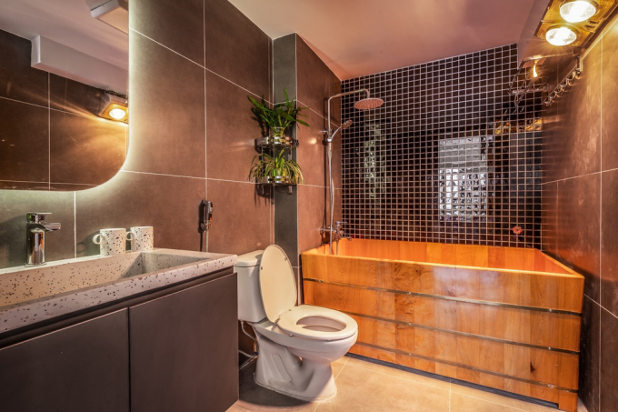 Nhà vệ sinh cũng thể hiện được toàn bộ tinh thần tối giản song vẫn hiện đại của căn nhà với bồn tắm gỗ độc đáo, hệ thống vòi hoa sen và một mảng xanh trên góc tường.