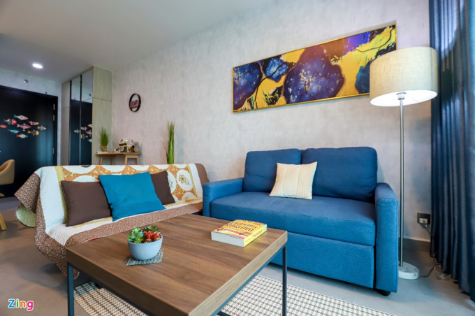 Không gian phòng khách dùng màu xanh và vàng làm điểm nhấn, còn lại chủ nhà phần lớn lựa chọn những gam màu trầm, vừa mang lại cảm giác ấm cúng mà không bị nhàm chán. Ngoài ra, mặc dù diện tích hạn chế, sofa được bố trí cạnh ban công lớn khiến không gian thoáng đãng, tràn ngập ánh sáng tự nhiên.