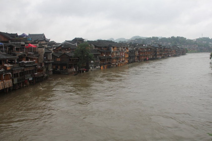 Từ tối 25/6, Phượng Hoàng cổ trấn, địa điểm du lịch nổi tiếng thuộc tỉnh Hồ Nam của Trung Quốc, đã có mưa lớn liên tục, làm nước sông Đà Giang tràn bờ.