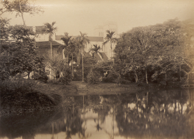 Ao nước cạnh bên Nhà thờ Lớn (có thể thấy nhà thờ sau những cây cau), Hà Nội thập niên 1890. Ảnh: Bunum.univ-cotedazur.fr.