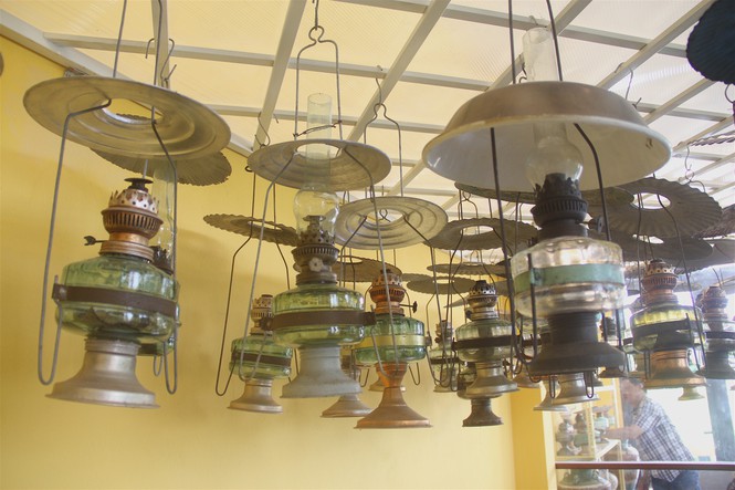Bên trong căn nhà, chủ nhân trưng bày khoảng hơn 2.000 món đồ cổ vật bằng đồng, đèn dầu, máy móc, lư, tiền cổ…
