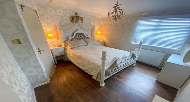 Cận cảnh 1 trong 2 phòng ngủ ở Royal Caravan. Căn phòng này có đèn chùm, tủ để đồ và ấn tượng nhất là màn che đầu giường với vương miện 