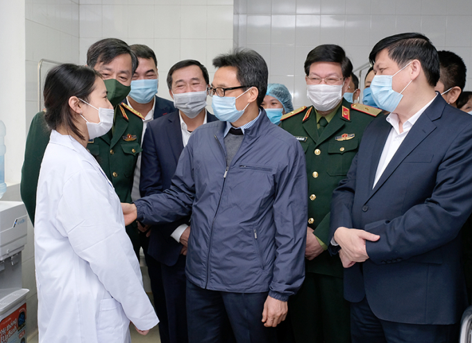 Phó Thủ tướng Chính phủ Vũ Đức Đam và Bộ trưởng Bộ Y tế Nguyễn Thanh Long trò chuyện với một nữ tình nguyện tiêm vắc xin COVID-19 liều 25mcg ngay từ đợt đầu tiên. Nữ tình nguyện cho biết: 