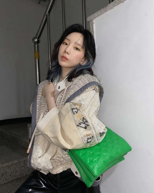 Không chỉ trang phục, Taeyeon còn lựa chọn cho mình phụ kiện tông xanh lá để bắt trend. Rõ ràng set đồ đơn giản nhờ chiếc túi hiệu màu nổi bật đã trở nên thú vị hơn gấp bội.