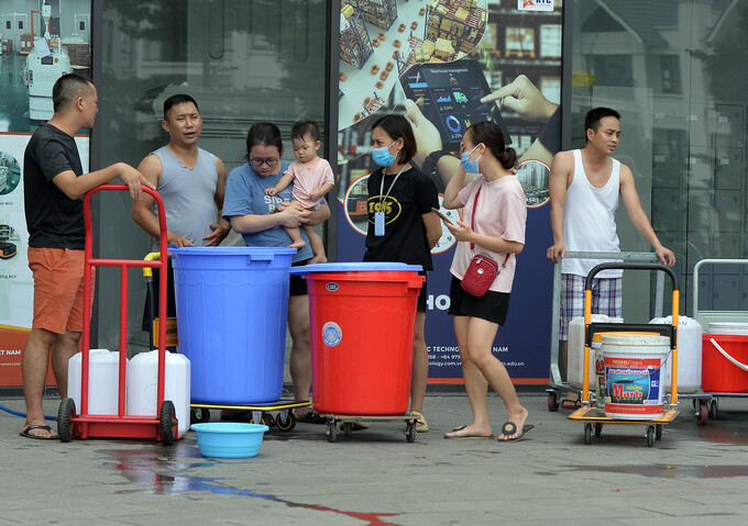 Người dân khu chung cư ở Hà Nội xếp hàng đợi được cung cấp nước sạch. (Ảnh: Quang Phong)