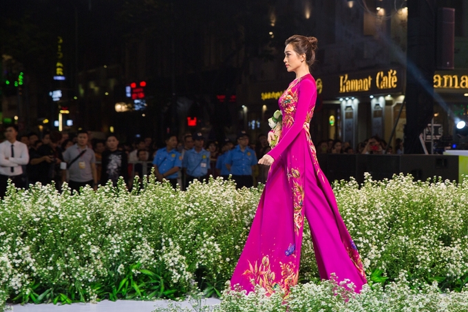 Á hậu Lệ Hằng diễn catwalk trong bộ áo dài truyền thống màu hồng đậm.