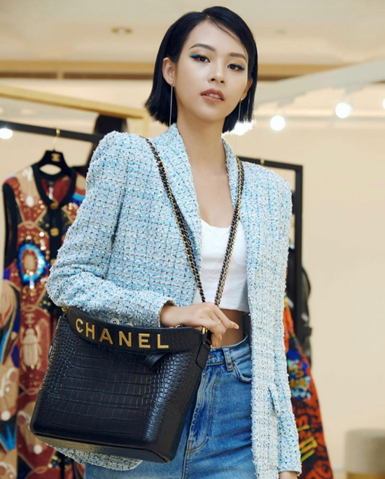  Phí Phương Anh chọn mẫu túi 'đắt hàng' của Chanel để mix cùng áo khoác vải tweed, jeans xanh cổ điển và áo hở eo tông trắng.