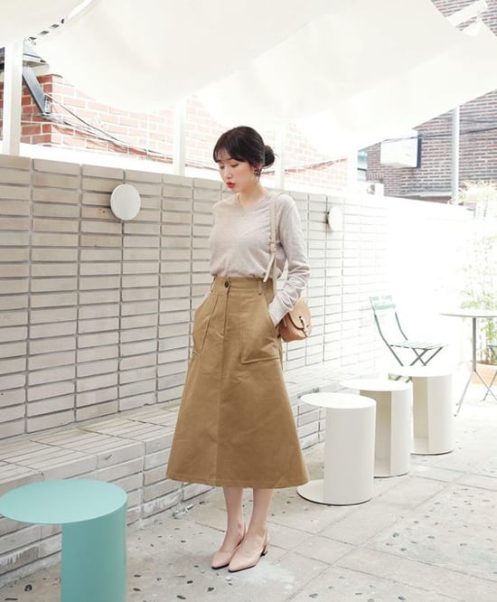  Chân váy vải thô, vải kaki tông nâu nhạt tiện lợi trong việc mix-match. Với kiểu váy này các nàng có thể sử dụng cùng sơ mi trắng, áo dệt kim tông nude, áo thun đen, áo ôm màu nâu đậm...