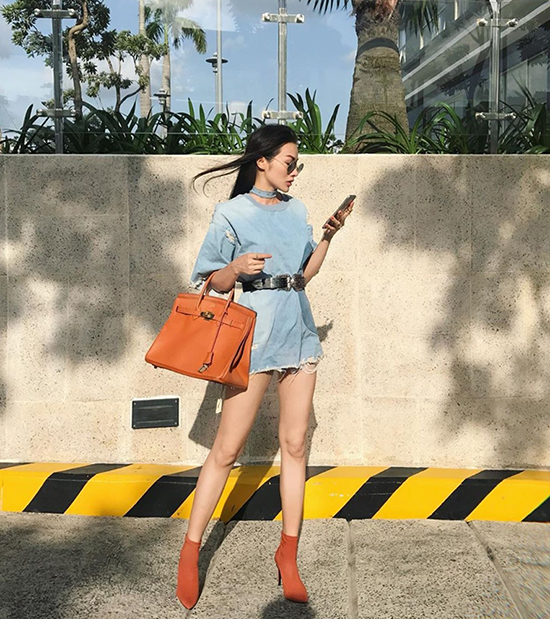 Trương Nhi chọn túi Hermes đồng điệu sắc màu bốt mũi nhọn khi diện váy denim xuống phố.
