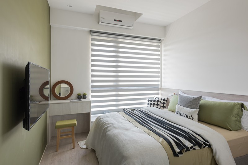  Không gian tổng thể phòng ngủ thứ nhất trang trí bằng màu sắc trung tính như xám và xanh ô liu để mang đến một giấc ngủ thoải mái.